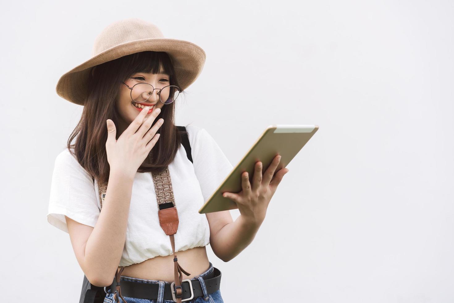 giovane donna asiatica guida viaggio utilizzare tablet dispositivo per smart tour sfondo bianco. foto