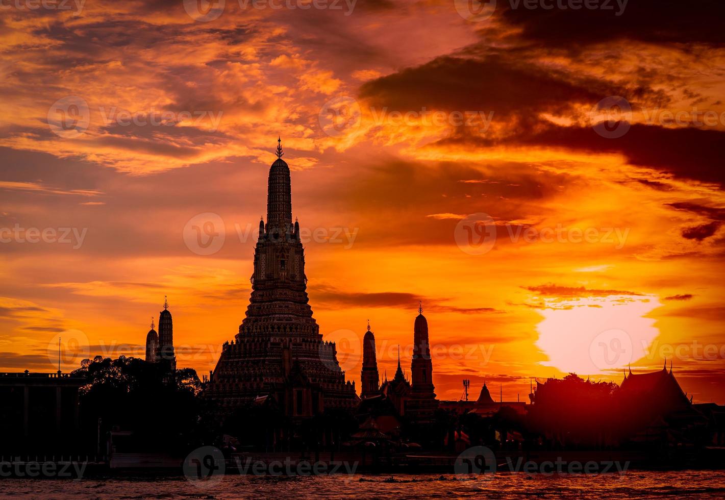 wat arun ratchawararam al tramonto con un bel cielo rosso e arancione e nuvole. il tempio buddista di wat arun è il punto di riferimento a bangkok, in tailandia. attrazione art. sagoma cielo drammatico e tempio. foto