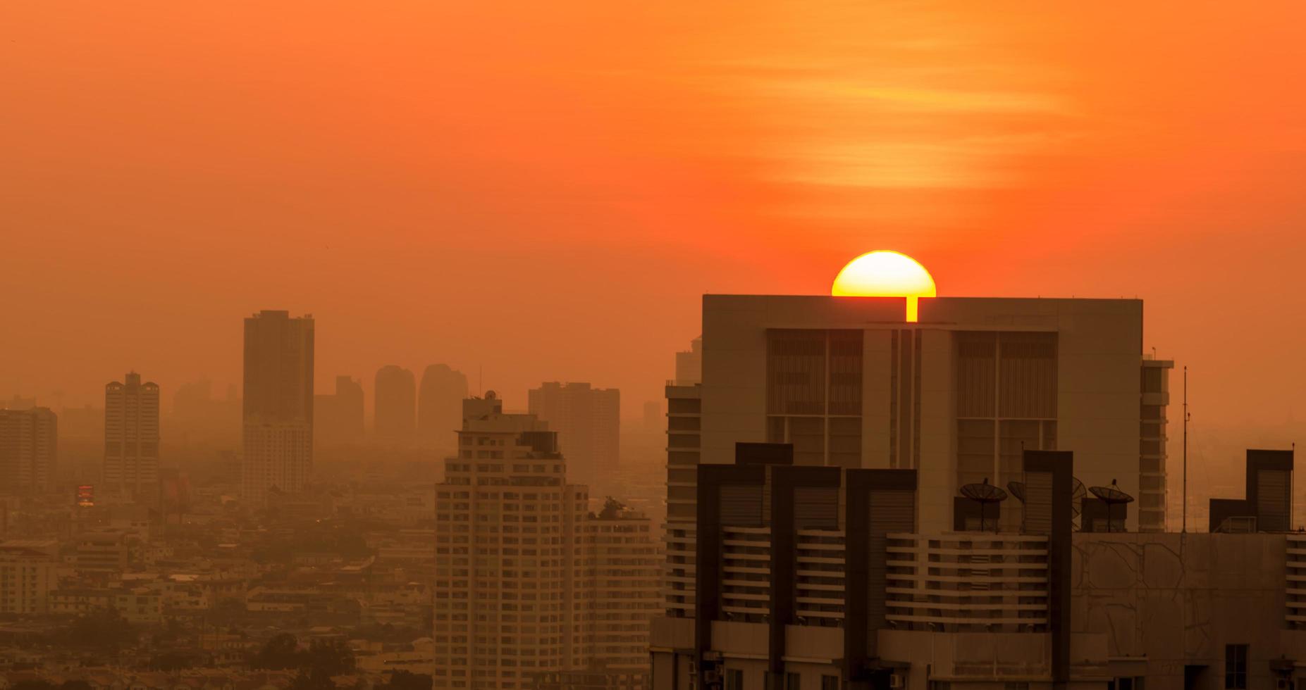 inquinamento dell'aria. smog e polvere fine di pm2,5 città coperta al mattino con il cielo arancione dell'alba. paesaggio urbano con aria inquinata. ambiente sporco. polvere tossica urbana. aria malsana. vita malsana urbana. foto