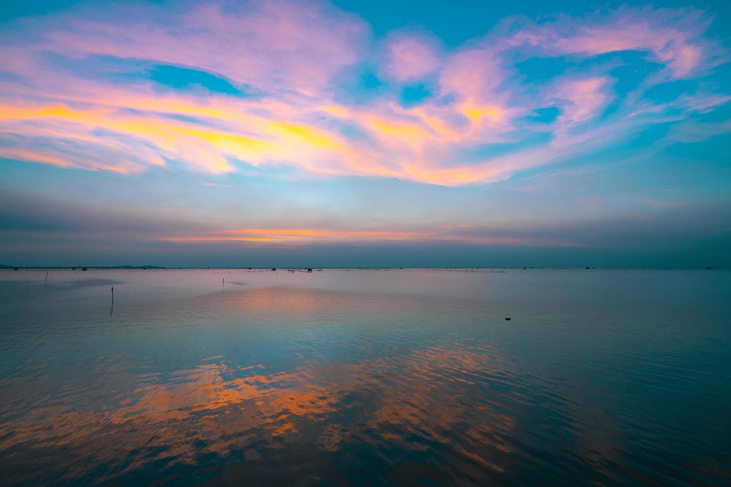 bel tramonto sul mare la sera. cielo blu e nuvole viola, arancioni e gialle. cielo drammatico e nuvole sulla spiaggia nel mare tropicale al tramonto. paesaggio marino con cielo dolce. calma e rilassati foto