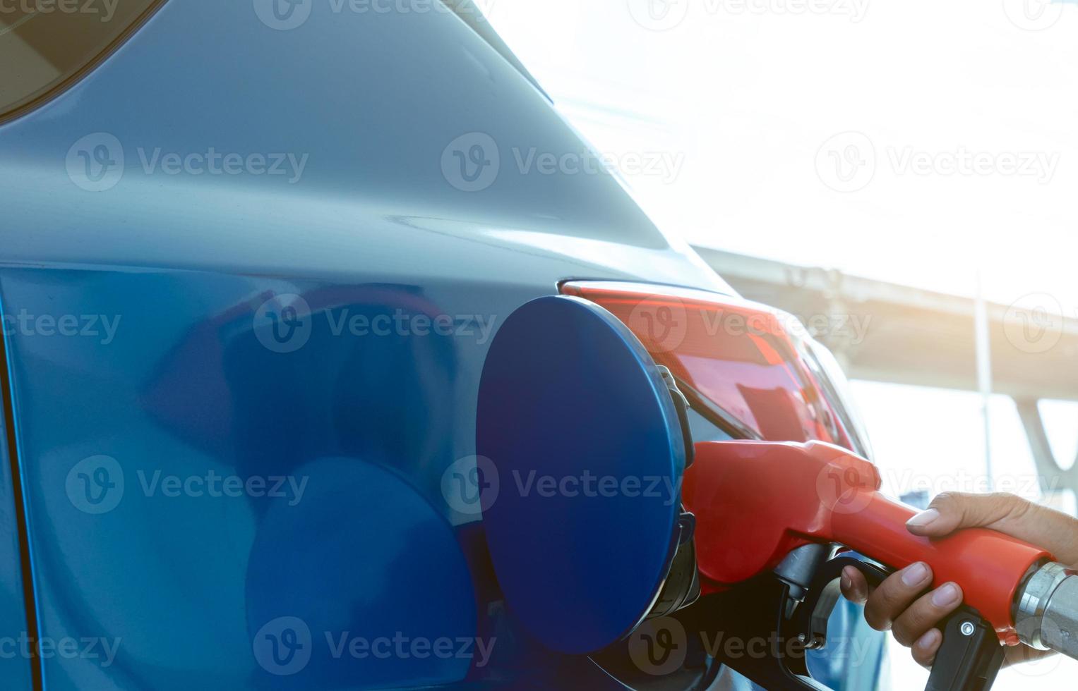 rifornimento auto alla stazione di servizio. fare rifornimento fare il pieno di benzina benzina. ugello del carburante di riempimento della pompa di benzina nel serbatoio del carburante dell'auto alla stazione di servizio. industria e servizi della benzina. prezzo della benzina e concetto di crisi petrolifera. foto