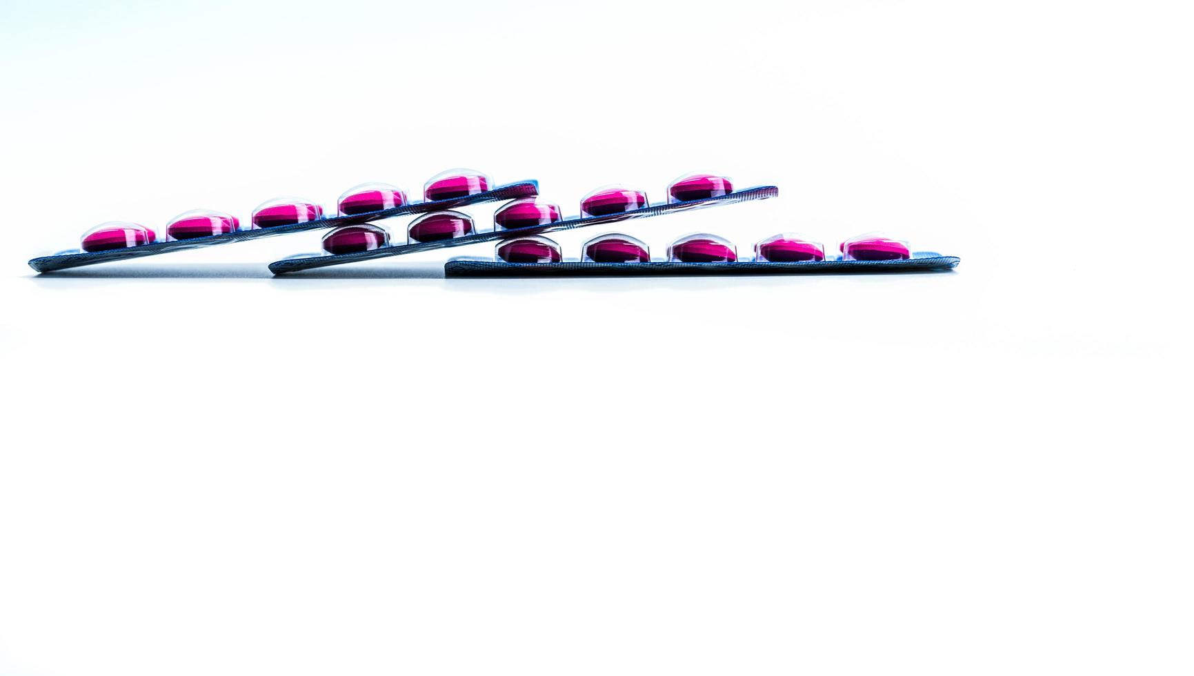 vista laterale della pillola di compresse rosa in blister isolato su sfondo bianco con spazio per la copia. ibuprofene per alleviare il dolore, mal di testa, febbre alta e antinfiammatorio. pillole antidolorifiche. concetto di assistenza sanitaria foto