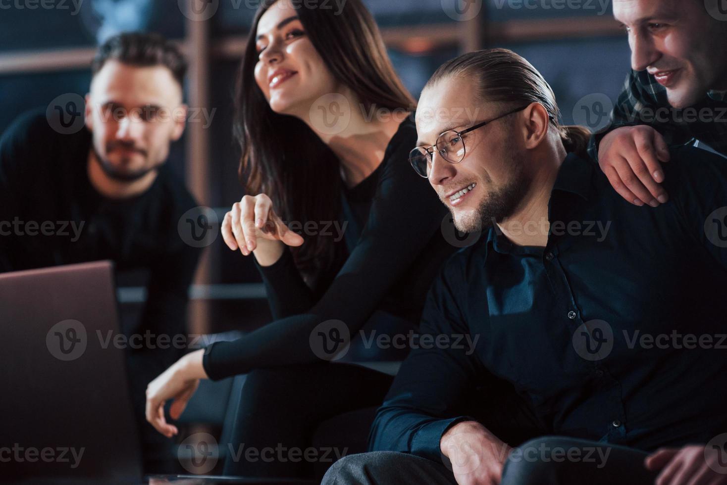 provare gioia insieme. team di giovani imprenditori lavora al loro progetto di notte in ufficio foto