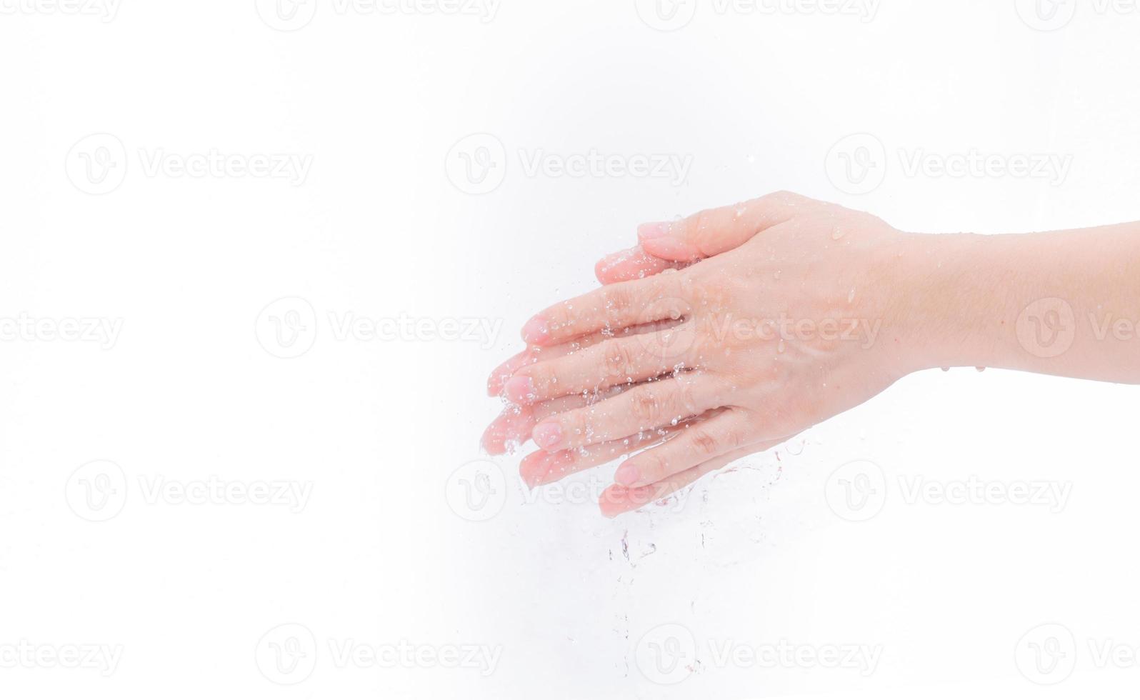 donna che si lava le mani con acqua isolata su sfondo bianco. buon concetto di igiene personale. primo passo per pulire le mani sporche per prevenire l'influenza e il coronavirus. donna adulta ammollo e bagnata con acqua. foto