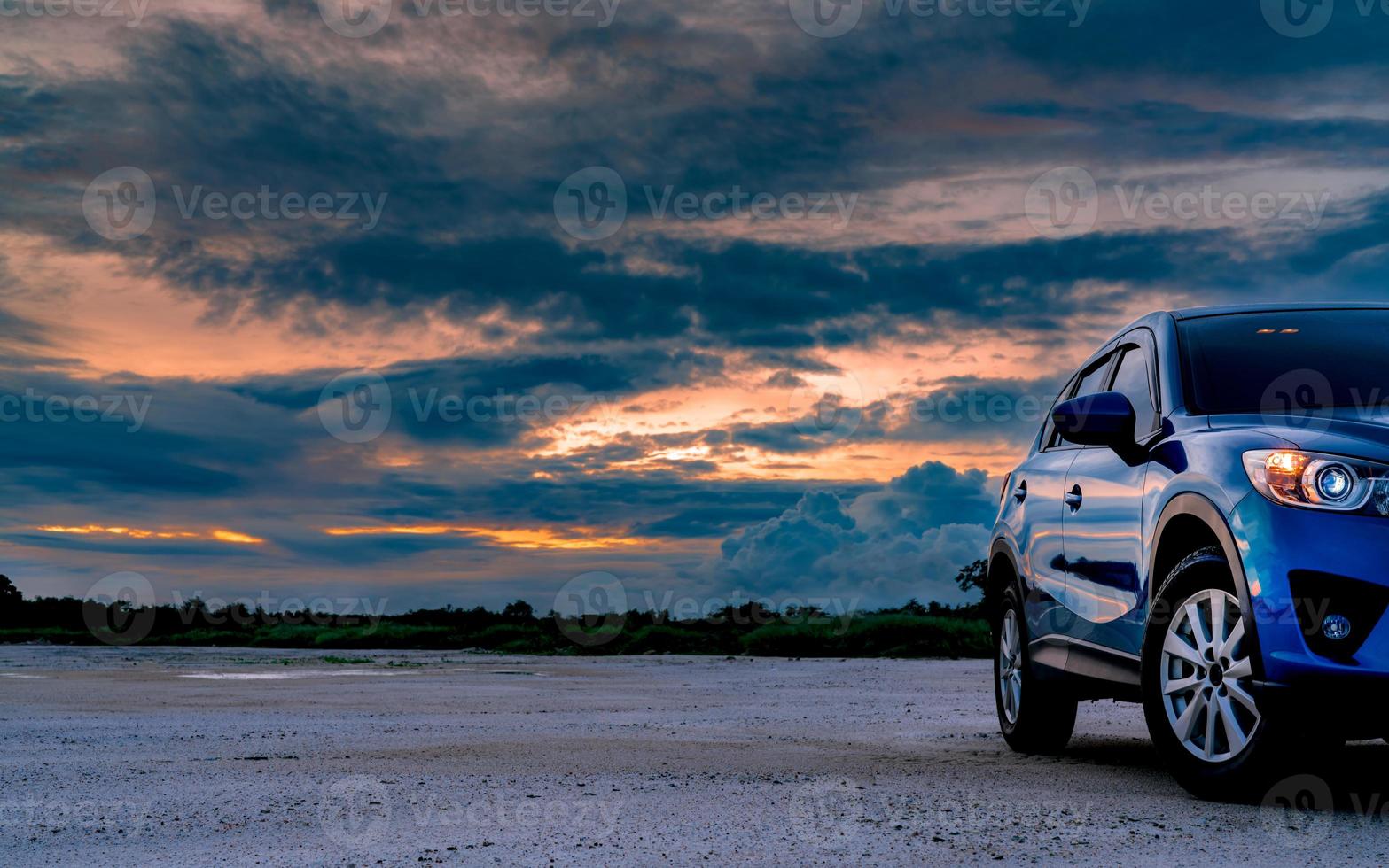 auto di lusso blu suv parcheggiata su un terreno accanto alla foresta tropicale con un bellissimo cielo all'alba. auto nuova dal design sportivo e moderno. in auto per un viaggio avventuroso. paesaggio naturale. industria automobilistica. foto