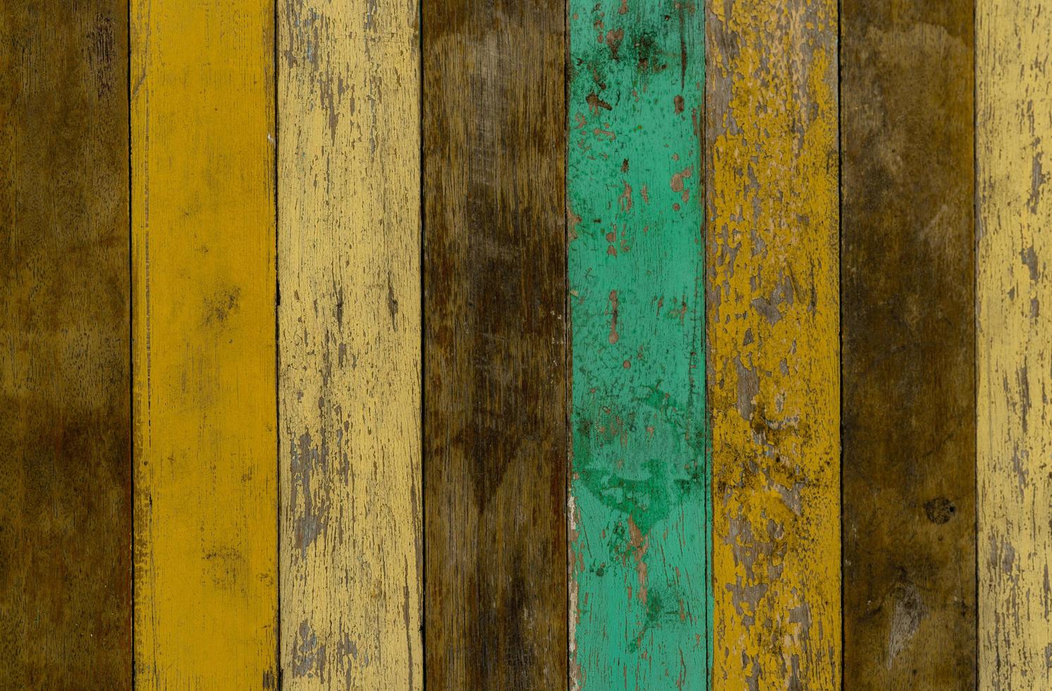 sfondo di struttura della parete di legno giallo, verde e marrone. vecchio pavimento in legno con vernice di colore screpolata. sfondo astratto in legno vintage con vernice scrostata. verde e giallo dipinto su struttura di legno marrone. foto