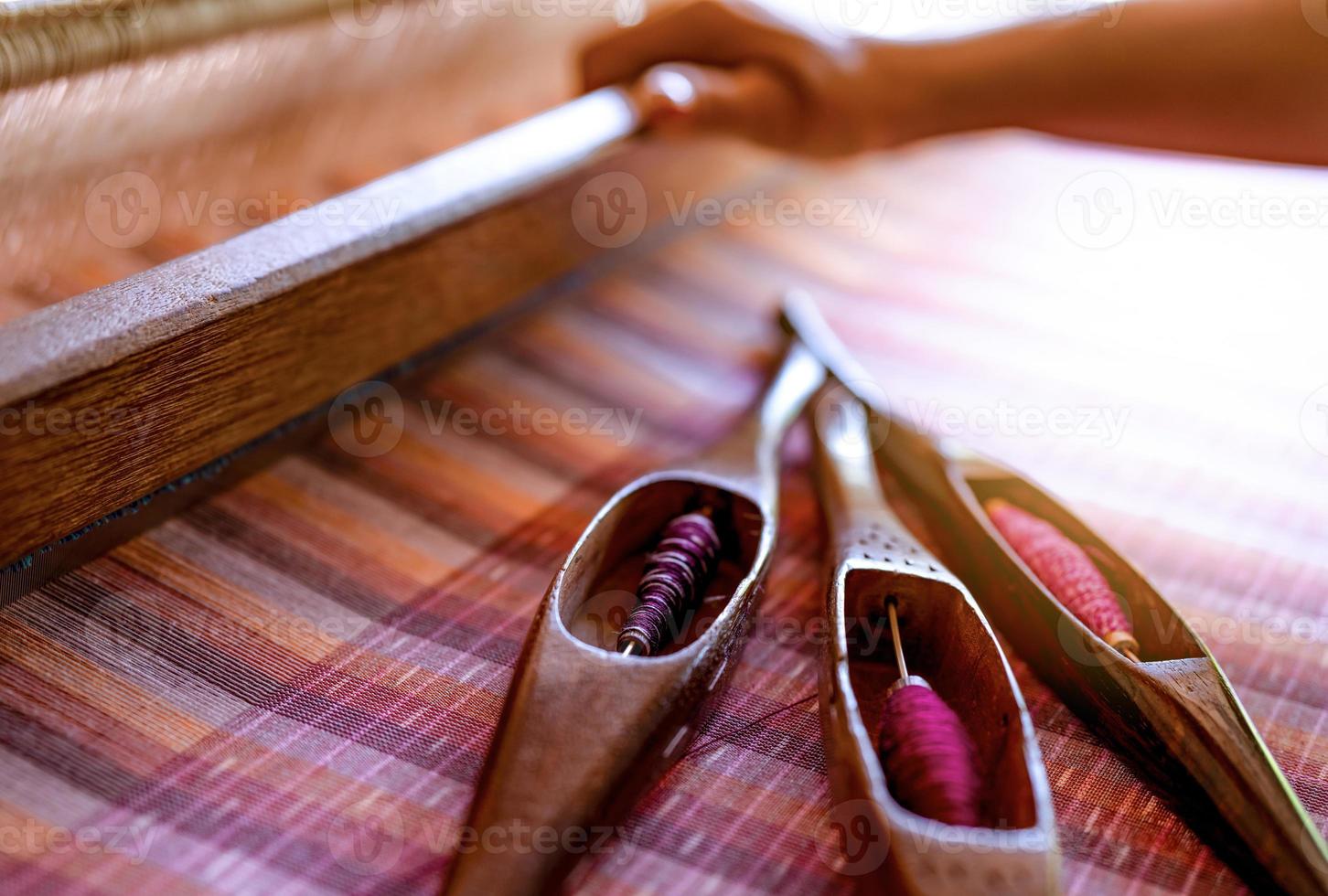 donna che lavora su macchina per tessere per tessere tessuti fatti a mano. tessitura tessile. tessitura con telaio tradizionale a mano su fili di cotone. produzione di tessuti o tessuti in Thailandia. cultura asiatica. foto