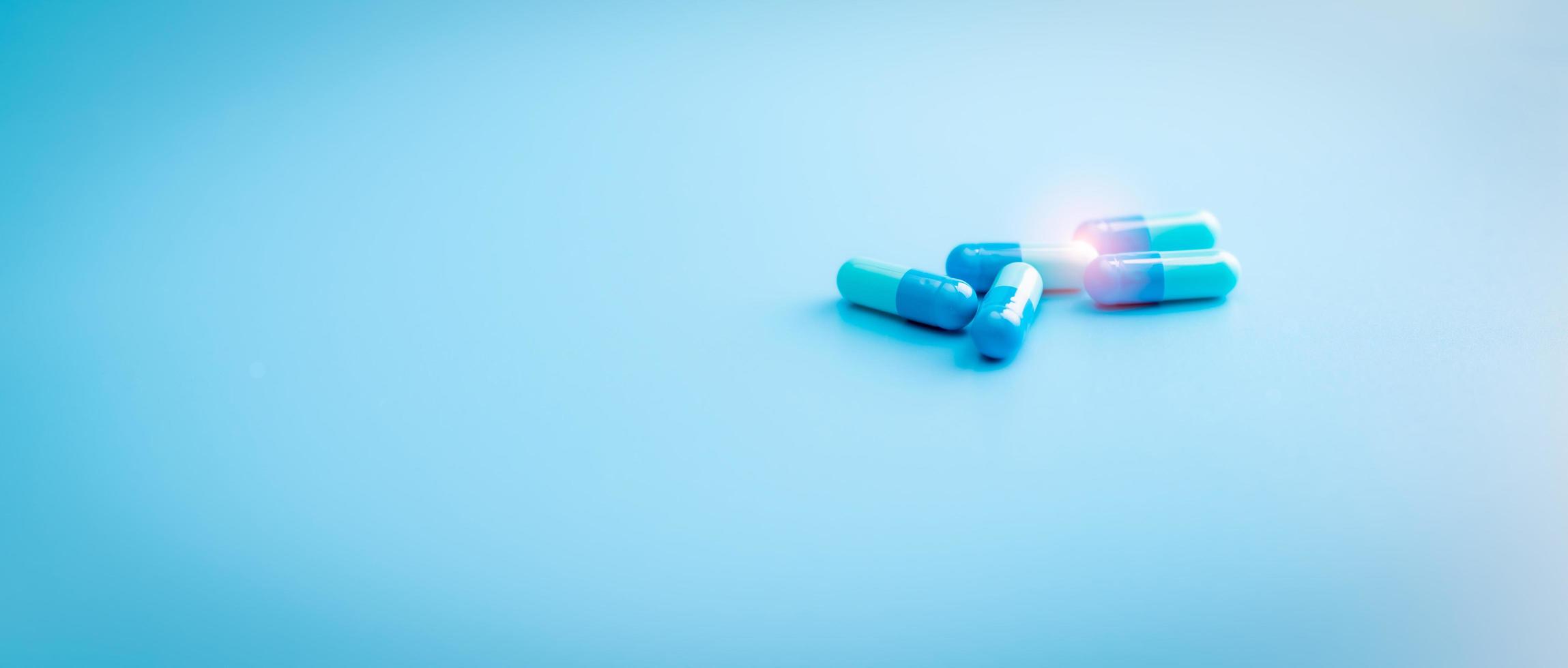 capsule blu su sfondo blu. banner del negozio di farmacia. industria farmaceutica. pillole di capsule antibiotiche. resistenza ai farmaci antibiotici. industria farmaceutica. farmaci da prescrizione. ricerca sui farmaci. foto