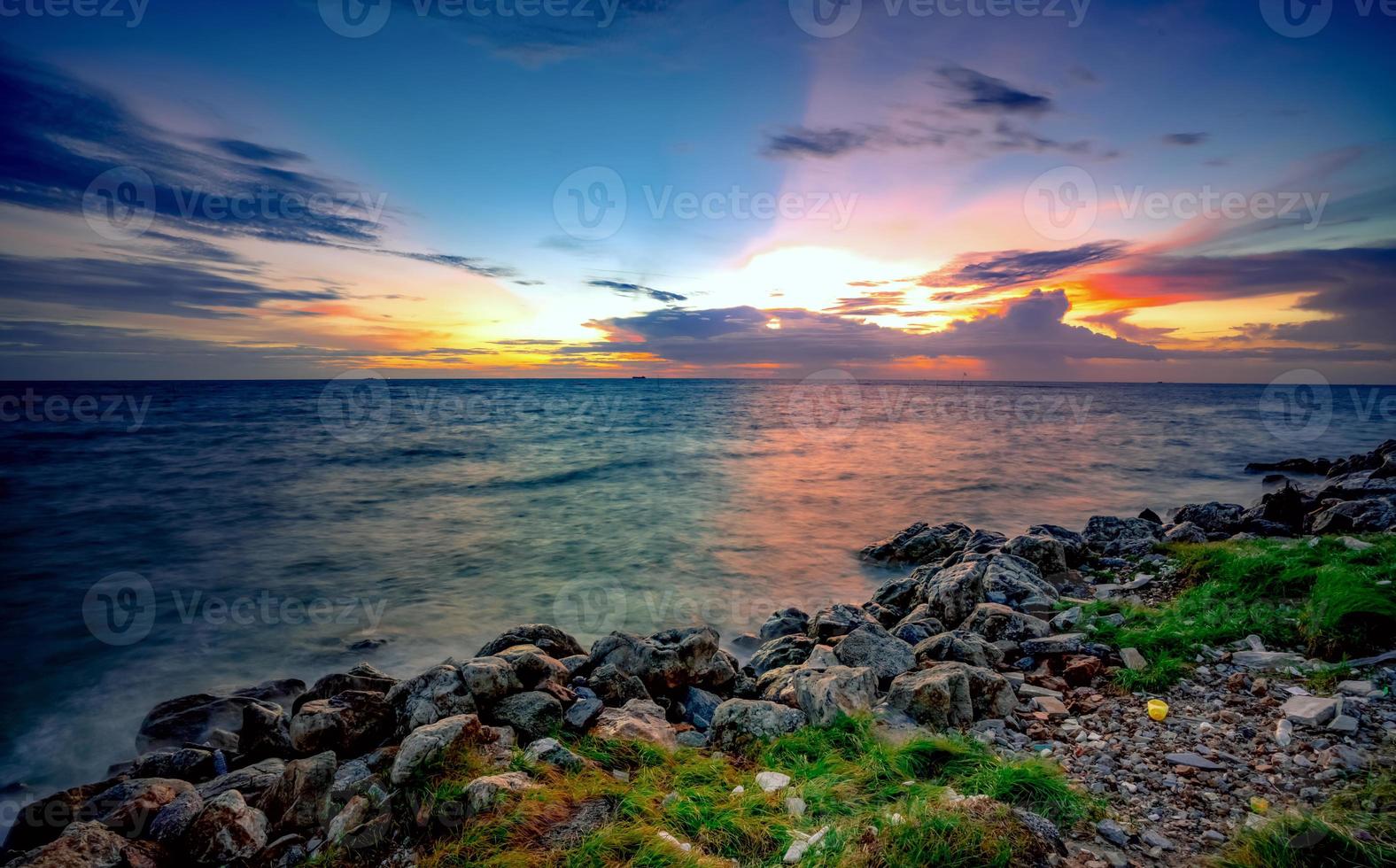 rocce sulla spiaggia di pietra al tramonto. bellissimo cielo al tramonto sulla spiaggia. mare e cielo crepuscolari. mare tropicale al tramonto. cielo e nuvole drammatici. calma e rilassa la vita. paesaggio naturale. concetto tranquillo e pacifico. foto