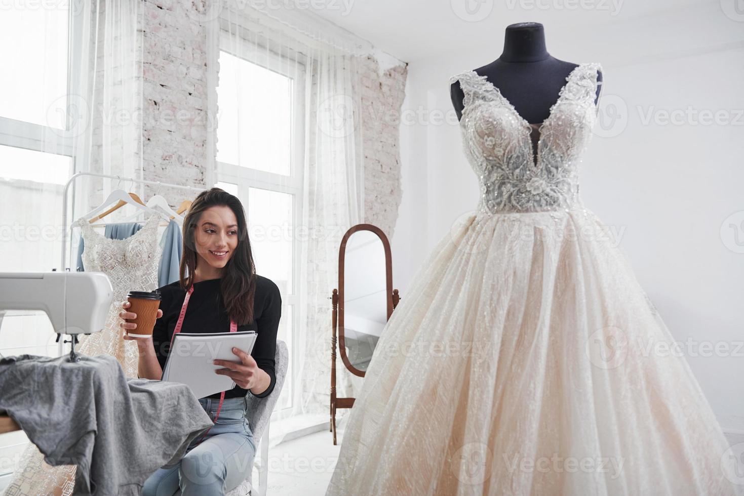 finalmente tempo di riposo. stilista femminile lavora sui nuovi vestiti in officina foto