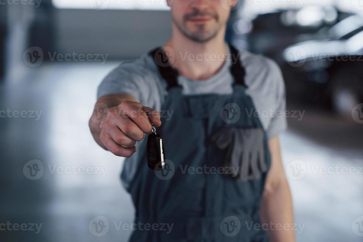 mano di meccanico con chiavi. la tua macchina è di nuovo in viaggio. lavoro ben fatto foto