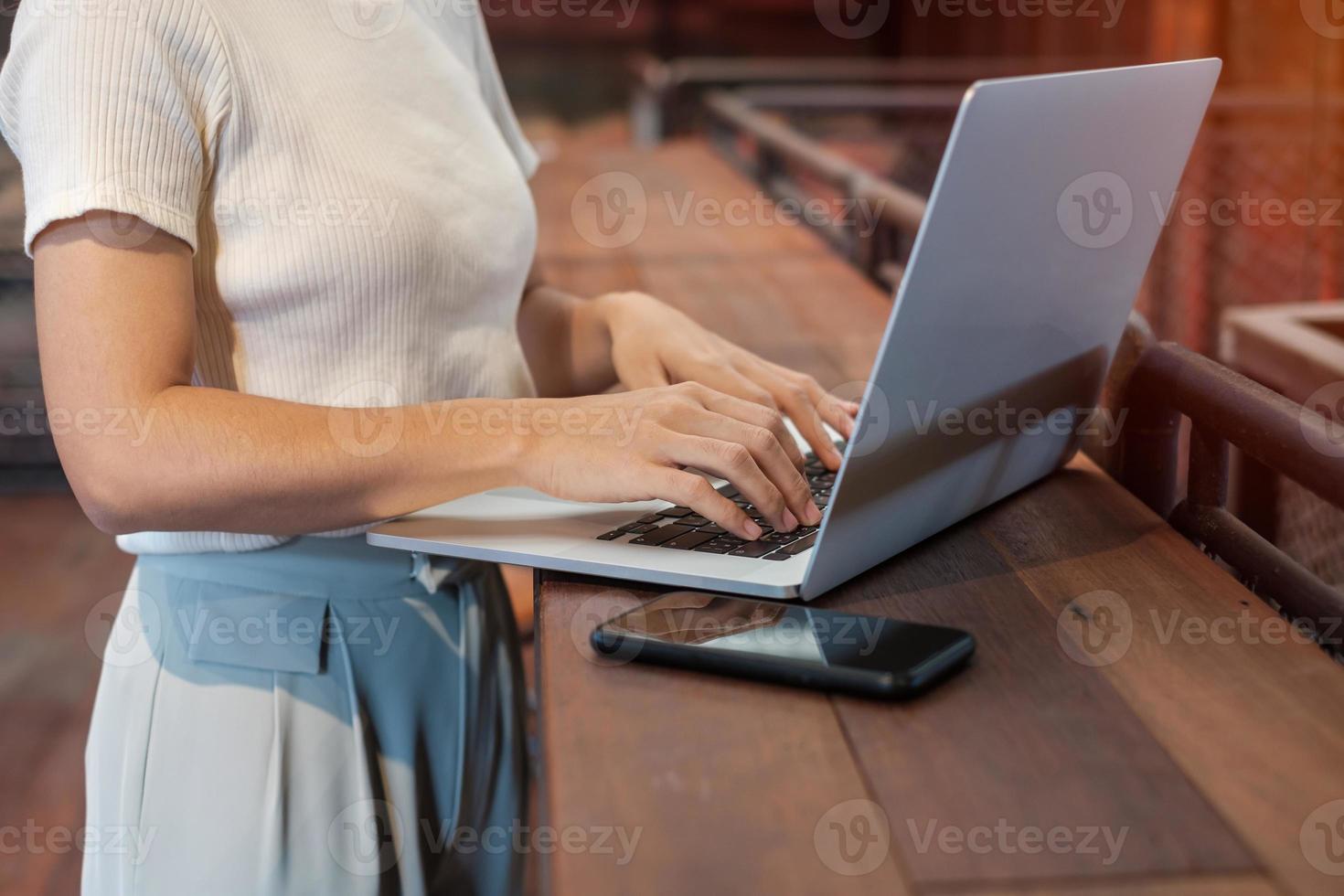 donna d'affari casual utilizzando laptop, donna freelance digitando tastiera computer notebook in caffè o ufficio moderno. tecnologia, digitale online e concetto di rete foto