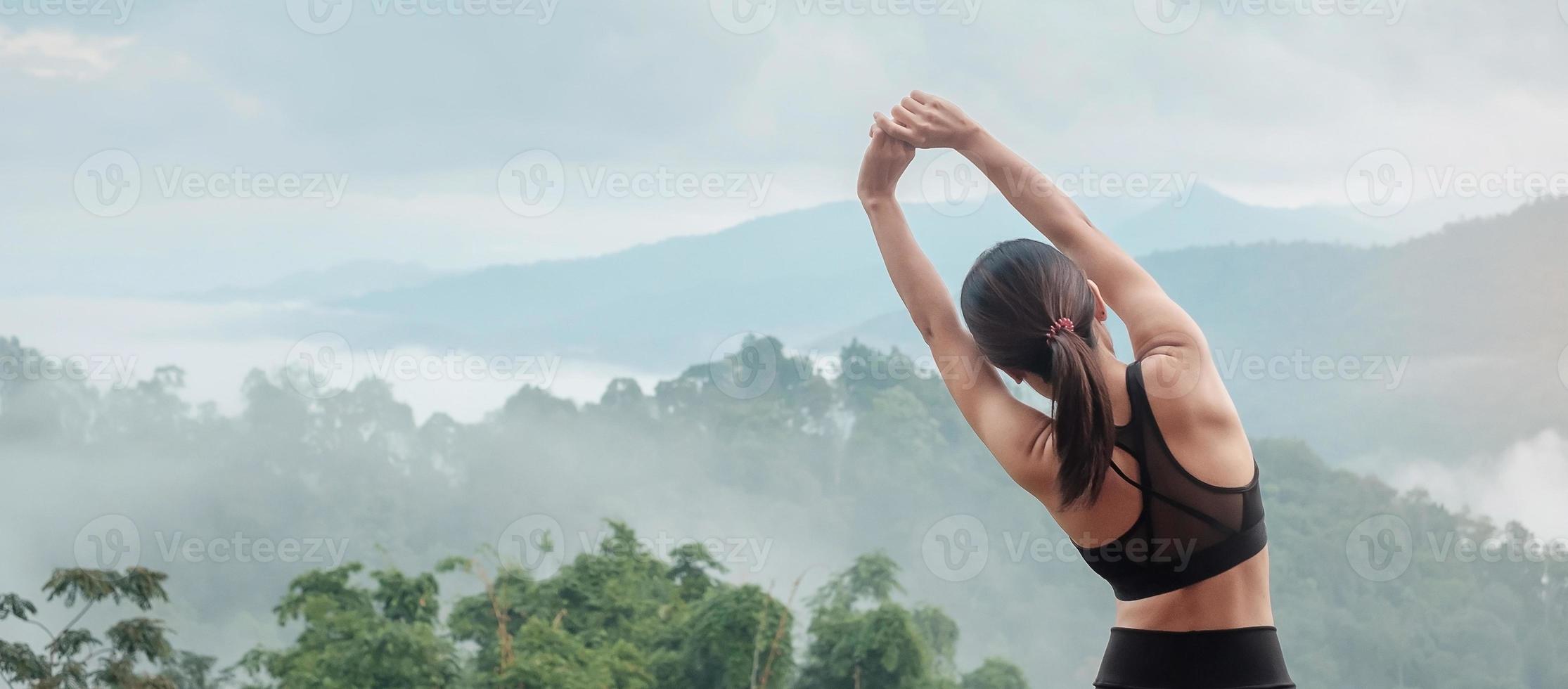 esercizio di donna atleta al mattino, giovane donna fitness che allunga i muscoli contro la vista sulle montagne, riscaldamento pronto per correre o fare jogging. concetti di allenamento, benessere e ragazza sportiva foto