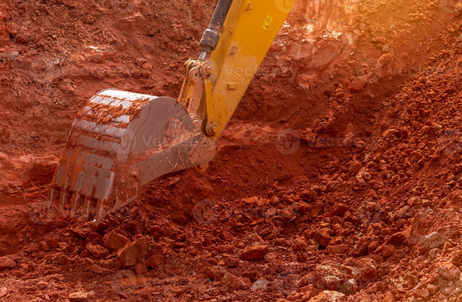 terne che lavorano scavando terreno in cantiere. secchio di terreno da scavo dell'escavatore a cucchiaia rovescia. escavatore cingolato che scava sullo sporco. secchio dell'escavatore a cucchiaia rovescia del primo piano di retroescavatore giallo. movimento terra. macchina per lo scavo. foto