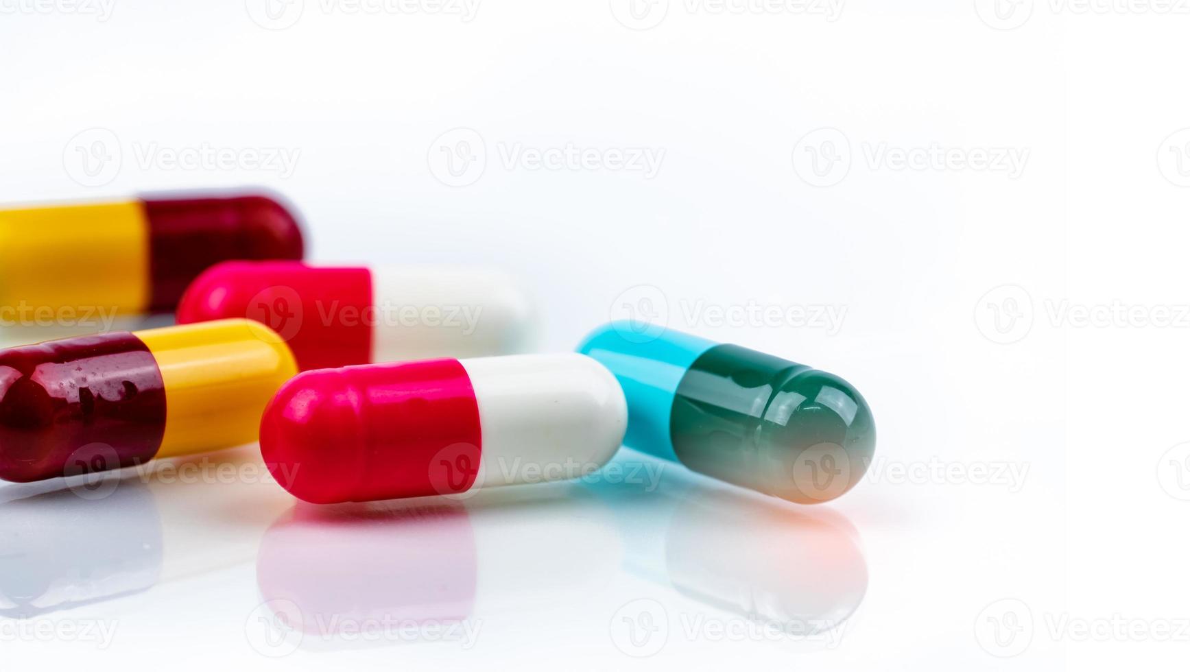 pillole colorate per capsule di antibiotici su sfondo bianco. resistenza ai farmaci antibiotici. industria farmaceutica. prodotti della farmacia. sfondo della farmacia. medicinale per il trattamento dell'infezione. assistenza sanitaria. foto