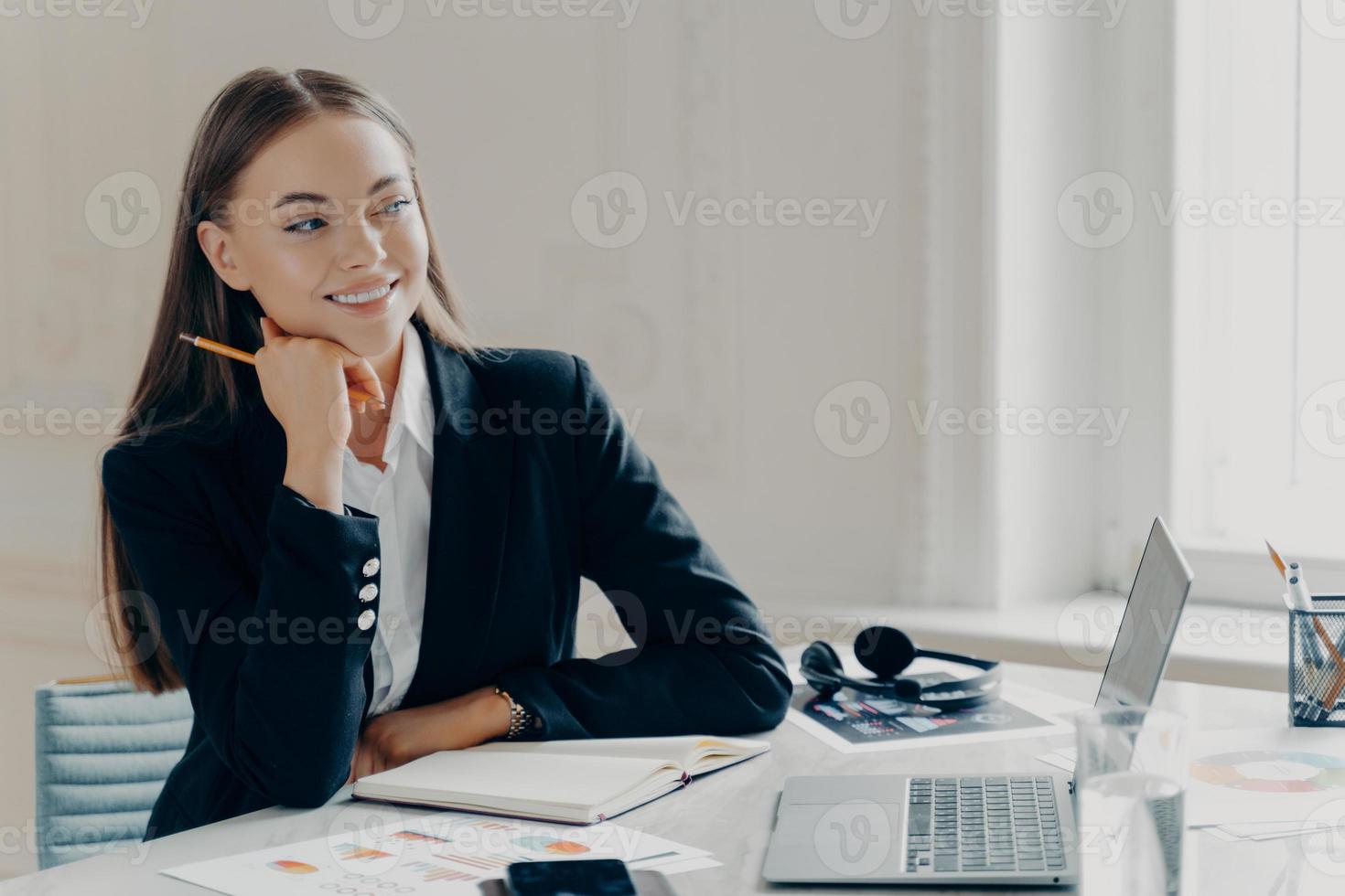 donna d'affari sorridente godendo la giornata di lavoro in ufficio foto