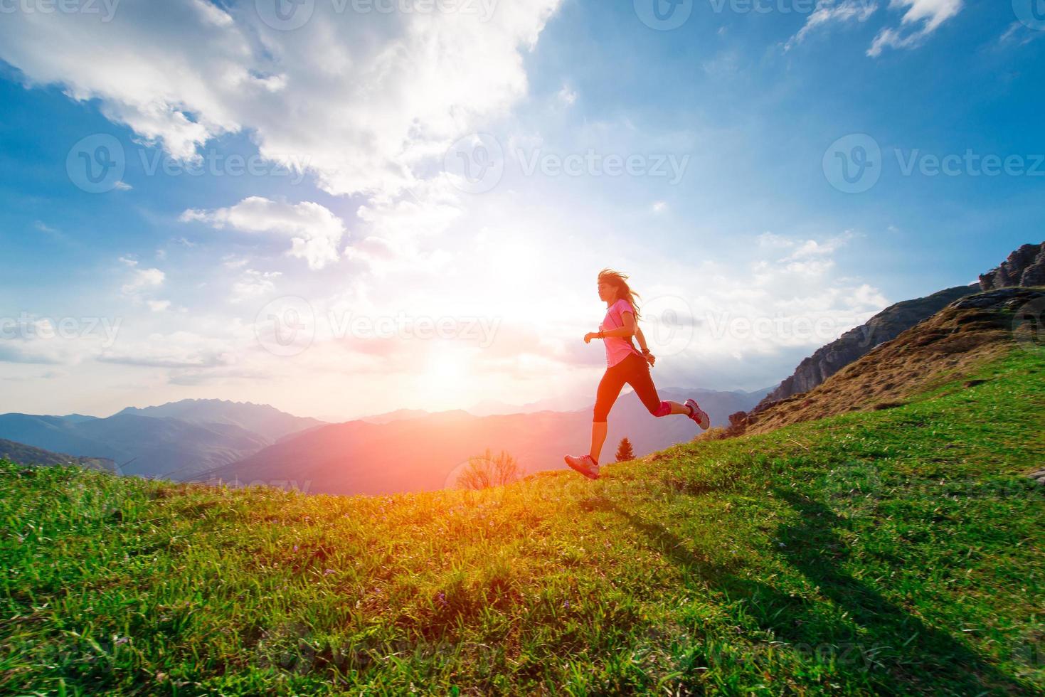 atleta femminile si allena in esecuzione nei prati collinari al tramonto foto