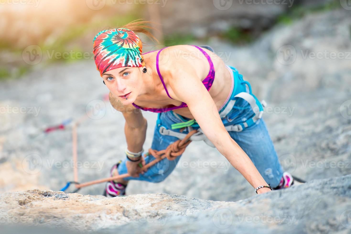 bella donna sportiva che si arrampica sulla roccia foto