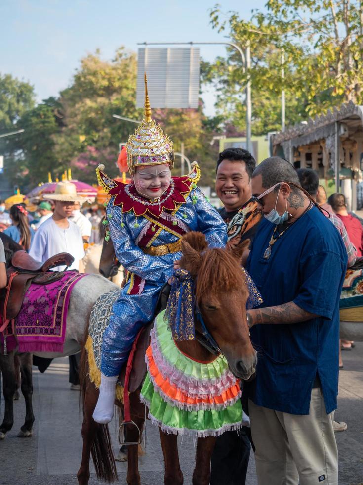 chiang mai, thailandia, 2020 - un ragazzo in abito tradizionale e popoli nella sfilata della cerimonia di ordinazione buddista. foto