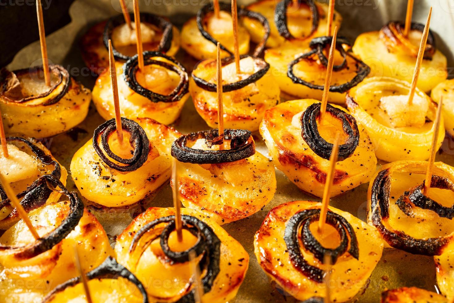 patate fritte rustiche con pancetta e cipolle primo piano in una padella foto