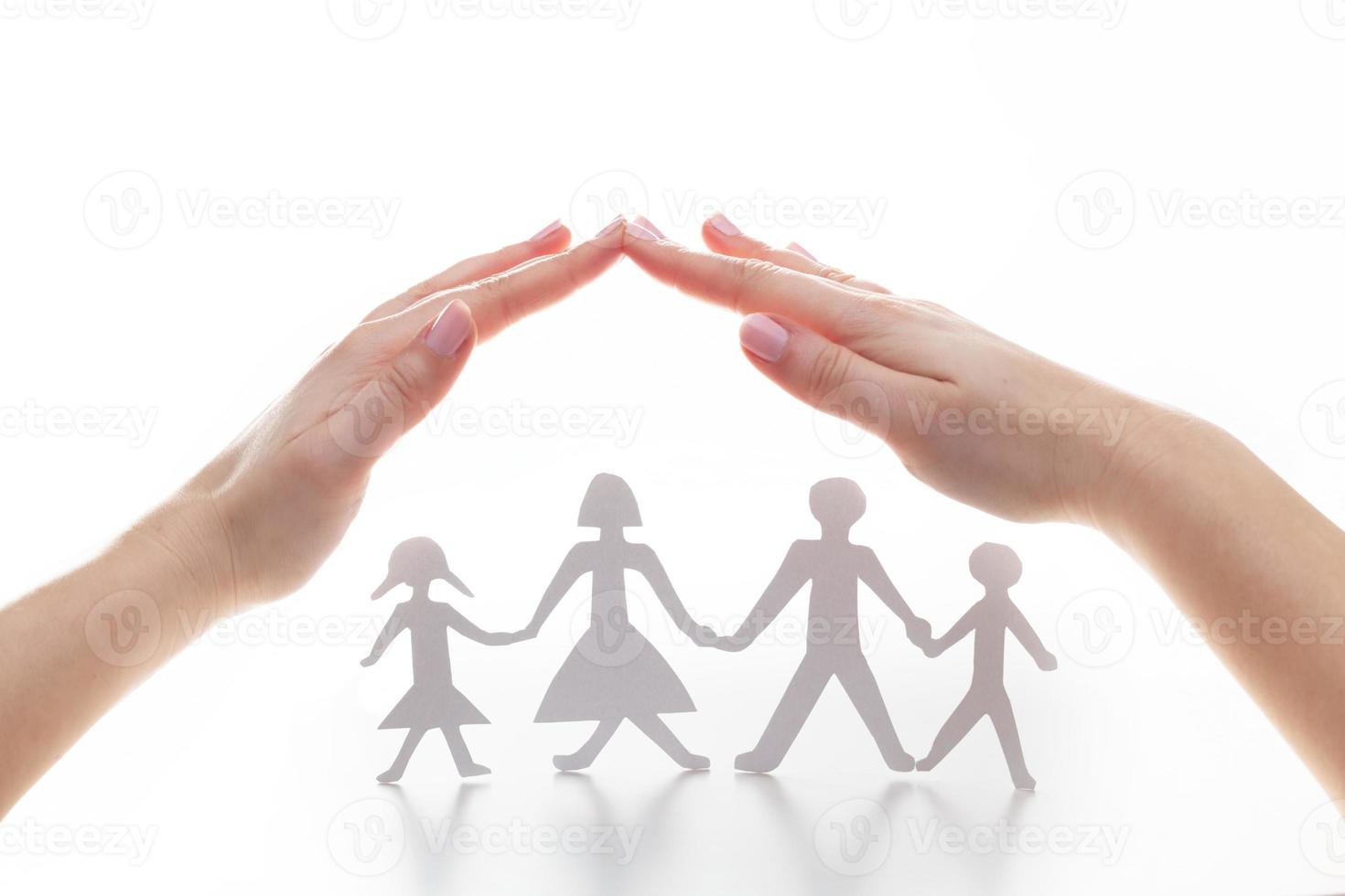 famiglia di carta sotto le mani in gesto di protezione. foto