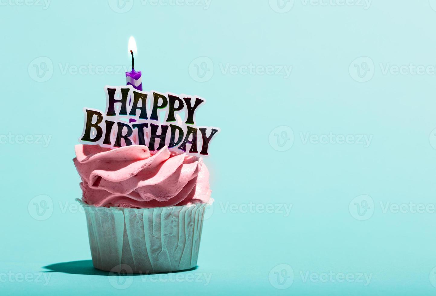 muffin di compleanno con candela su sfondo blu. foto