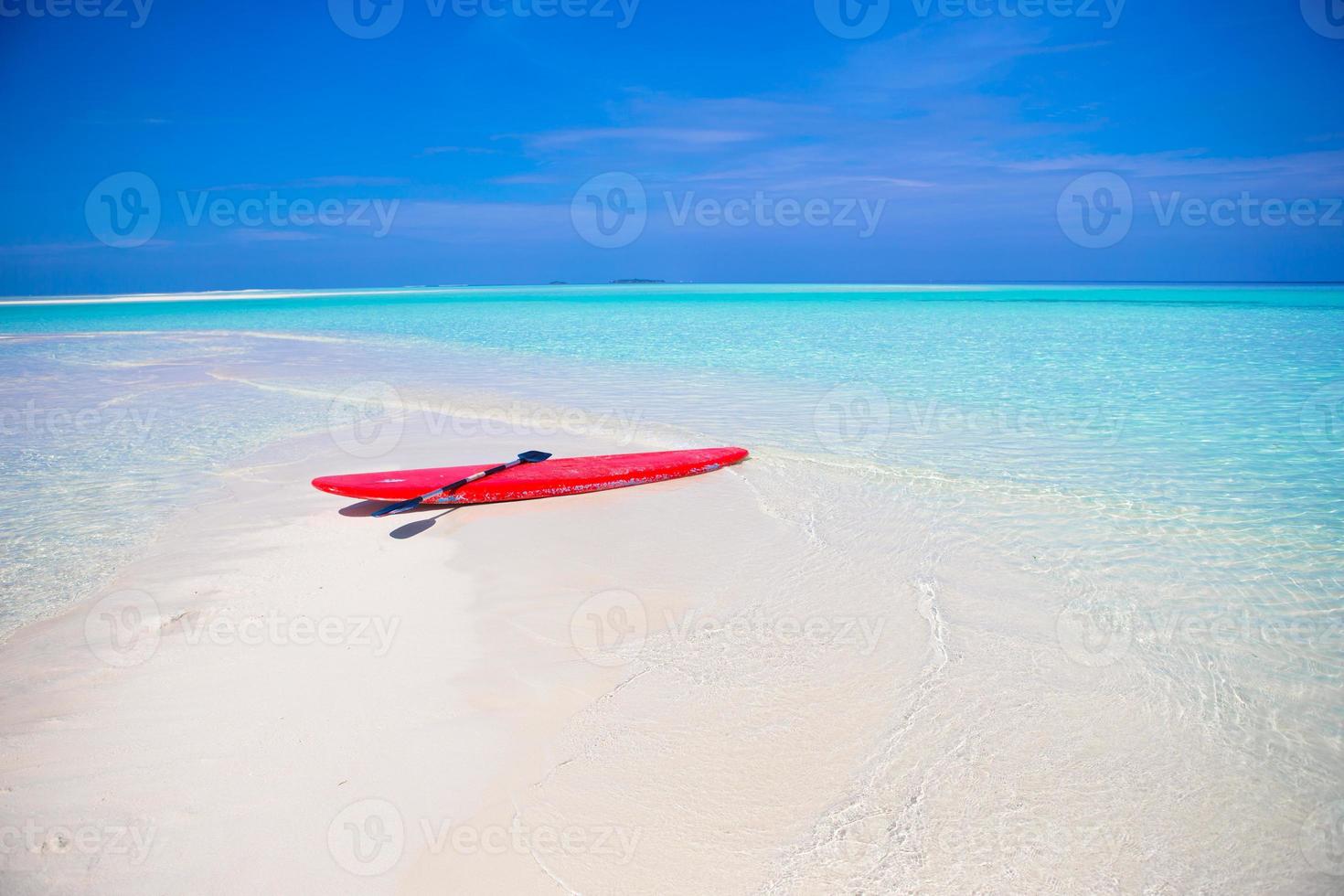 tavola da surf sulla spiaggia di sabbia bianca con acqua turchese foto