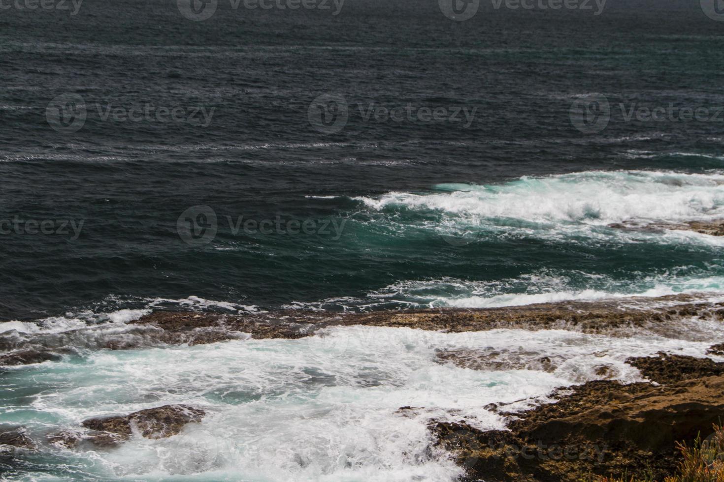 le onde che combattono sulla costa rocciosa deserta dell'Oceano Atlantico, in Portogallo foto