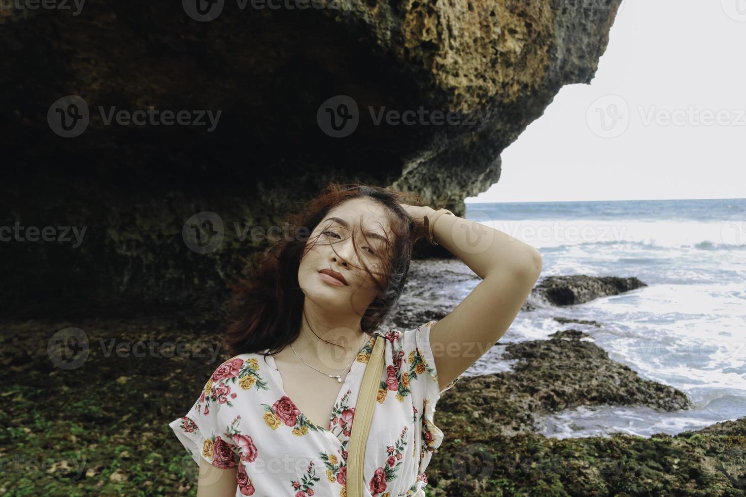 una giovane bella donna asiatica che lancia i suoi capelli sulla spiaggia foto