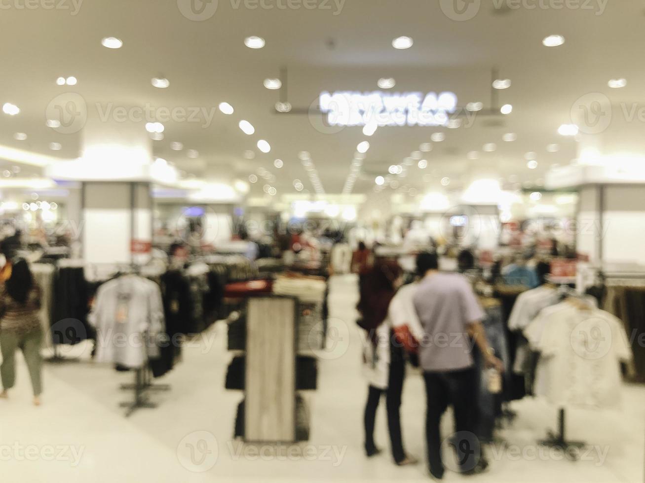 astratto sfocato dell'interno della boutique del negozio di abbigliamento di moda in un centro commerciale, con sfondo chiaro bokeh. foto