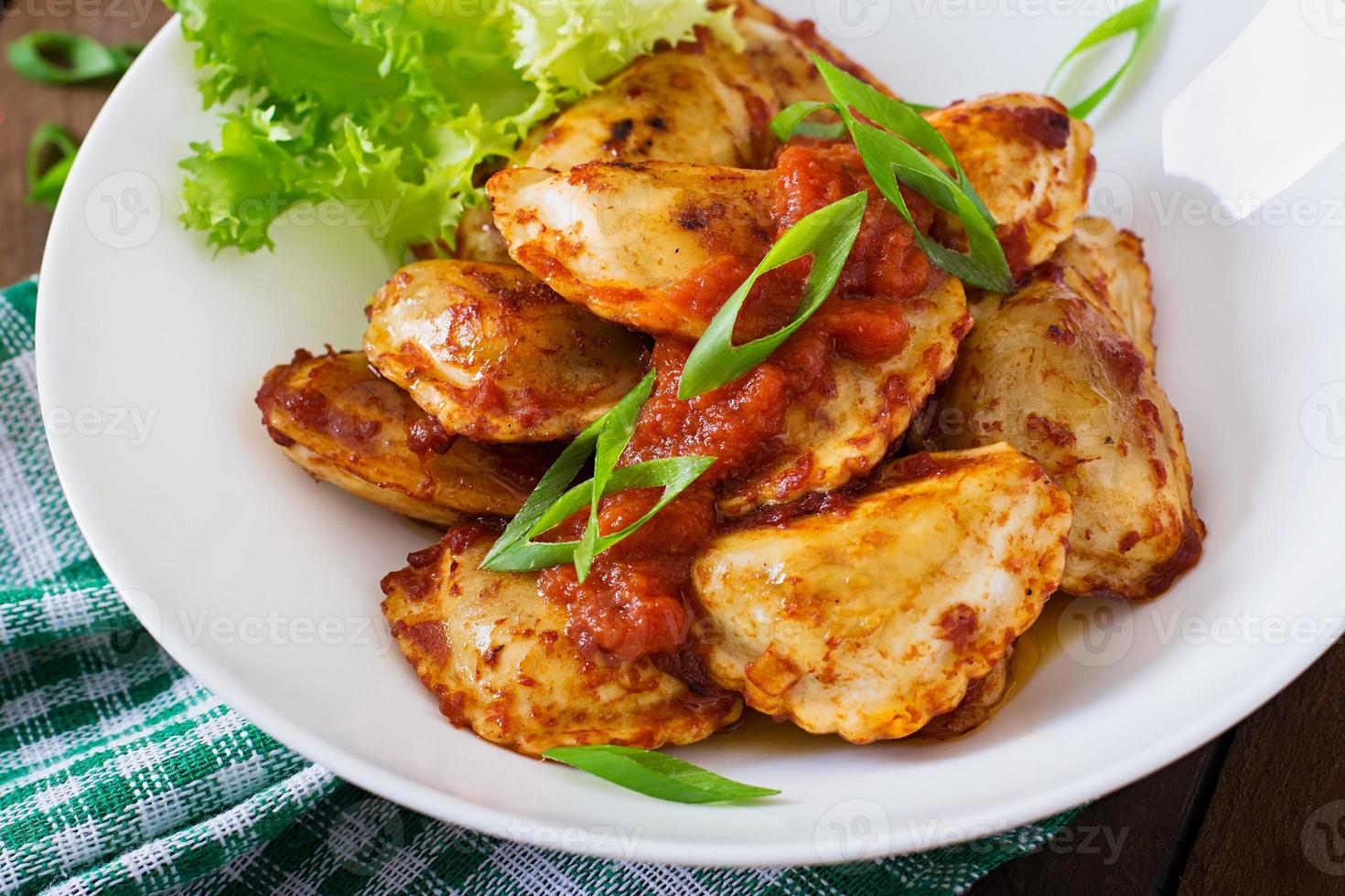 deliziosi ravioli con salsa di pomodoro e cipolle verdi foto