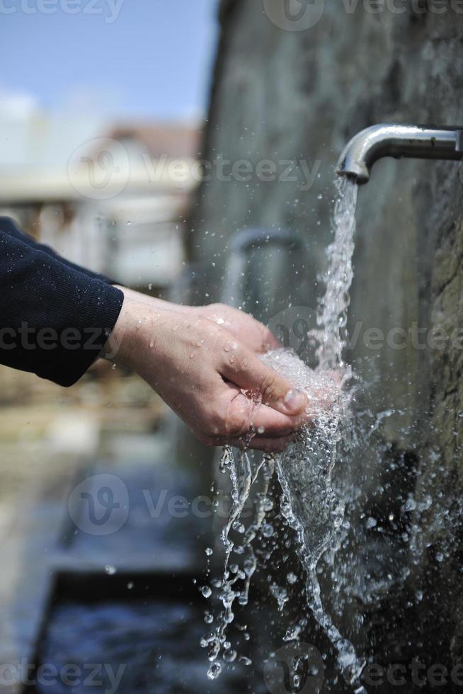 acqua fresca di montagna che cade sulle mani foto