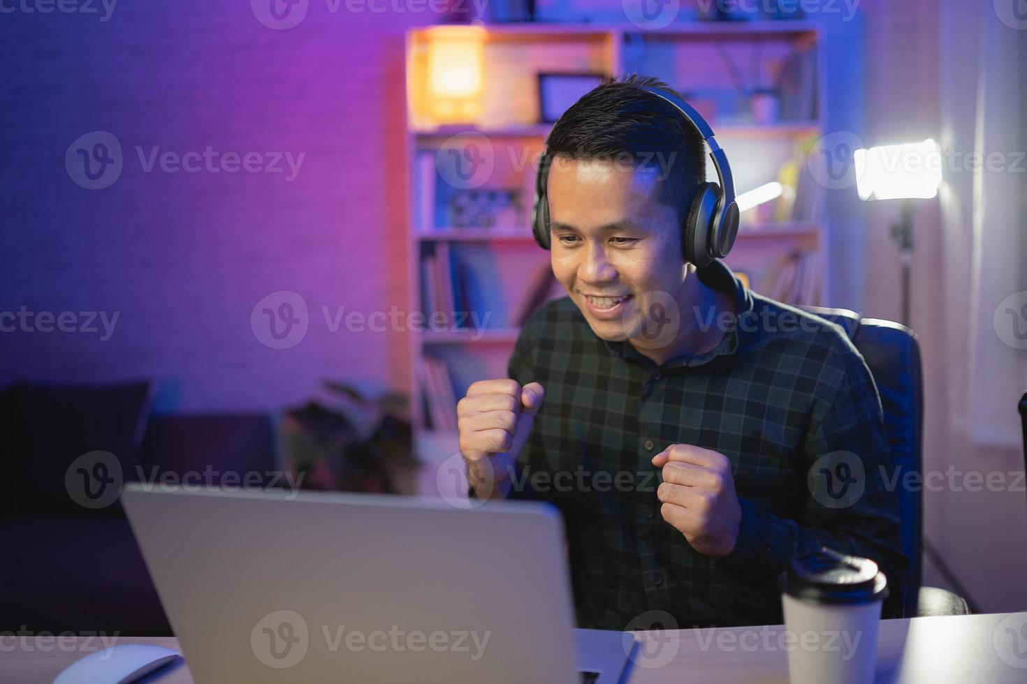uomo influencer asiatico sorriso youtuber in diretta streaming o conferenza di lavoro con laptop e cuffia con indosso. uomo asiatico che insegna online. foto