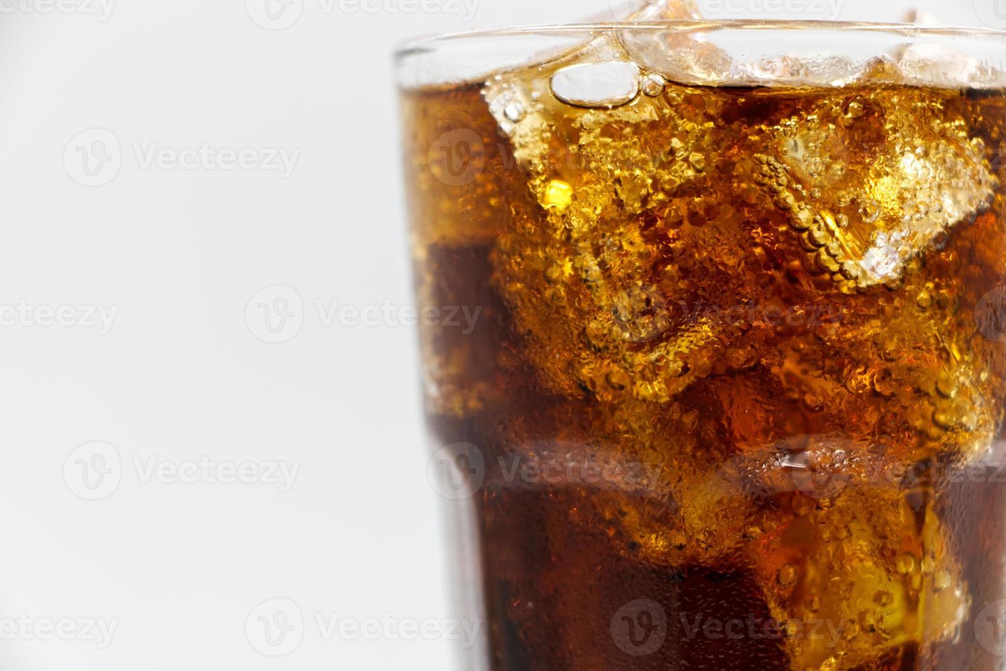 cola vetro con schiacciato su uno sfondo bianco cola ghiaccio in vetro e ci sono goccioline d'acqua intorno. bevanda fresca nera fresca. foto