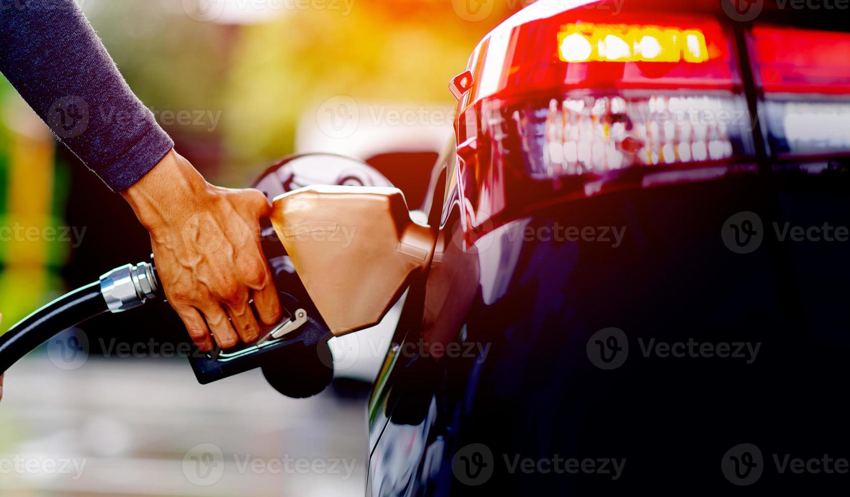 rifornire il carburante con l'ugello del carburante. rifornire l'auto alla stazione di servizio. riempire di benzina la stazione di servizio riempie gli iniettori di carburante nel serbatoio del carburante dell'auto presso la stazione di servizio. olio e servizio foto