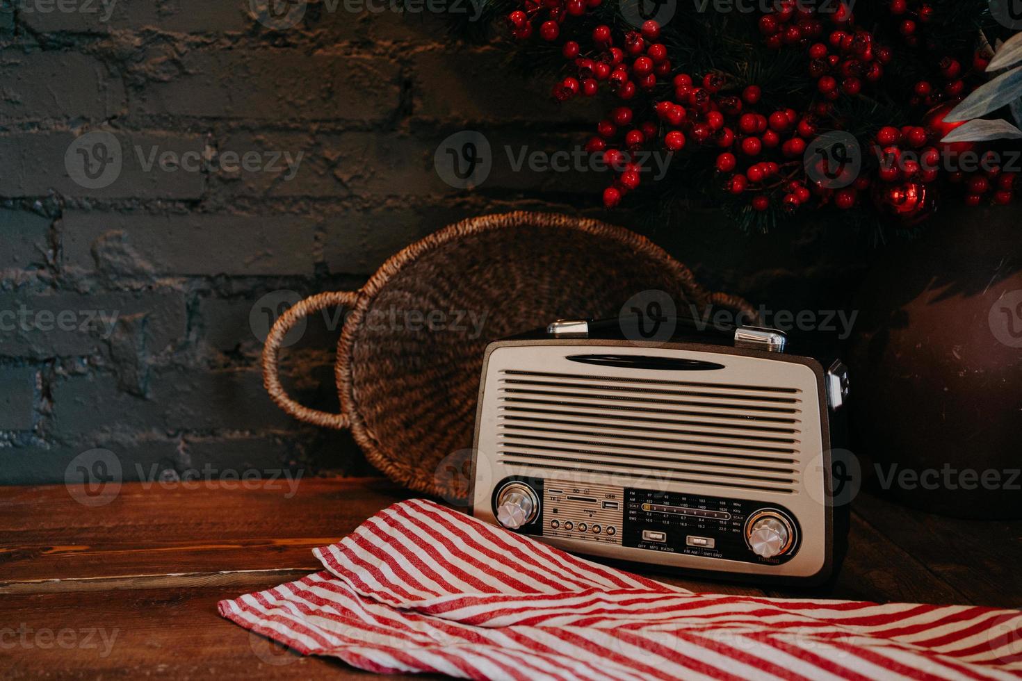 radio retrò su tavola di legno con cesto di vimini e decorazioni floreali. stile vintage. antico ricevitore radiofonico di trasmissione su fondo rustico. foto