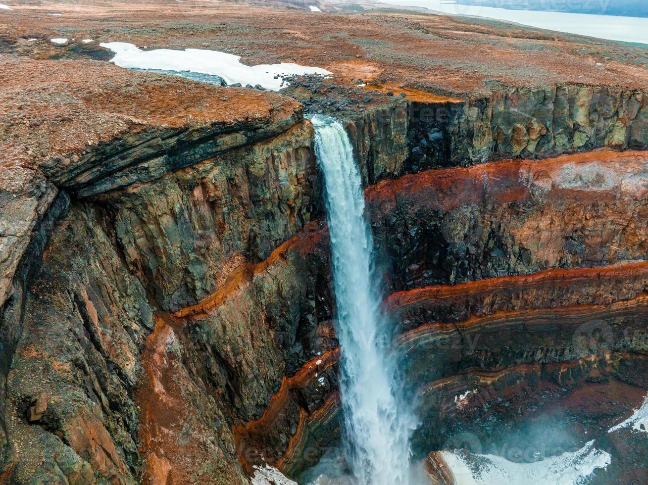 vista aerea sulla cascata di hengifoss con sedimenti a strisce rosse in islanda. foto