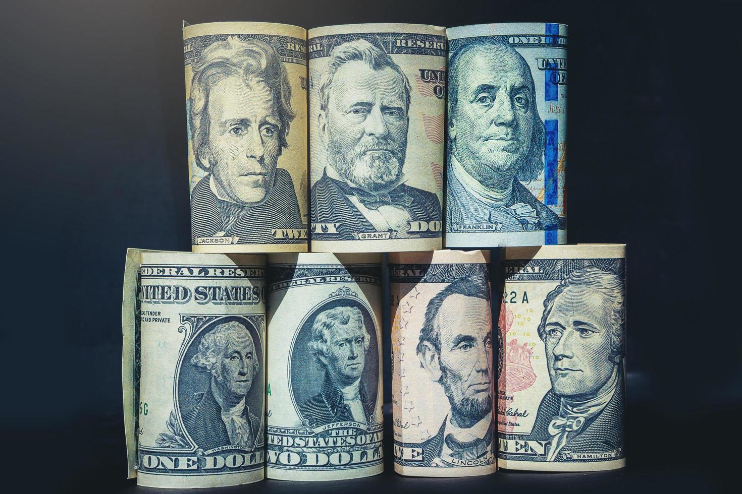 presidenti americani su banconote pila di denaro su sfondo scuro. messa a fuoco selezionata foto
