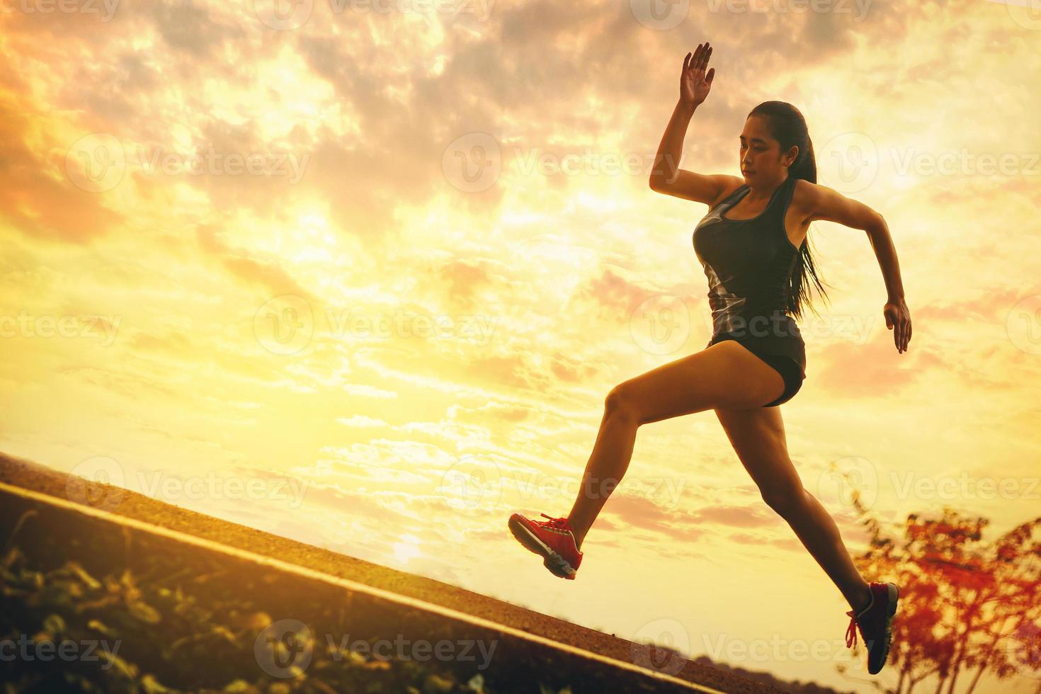 sagoma di giovane donna in esecuzione sprint su strada. in forma corridore fitness corridore durante l'allenamento all'aperto con sfondo tramonto. foto