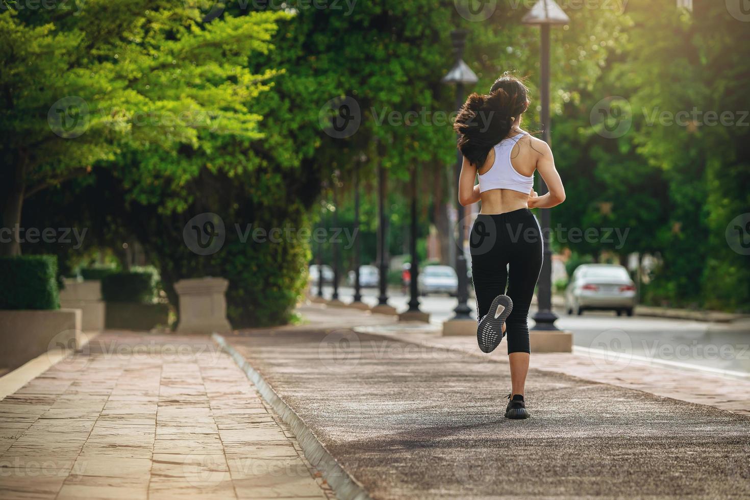 sagoma di giovane donna in esecuzione sprint su strada. in forma corridore fitness corridore durante l'allenamento all'aperto con sfondo tramonto. foto