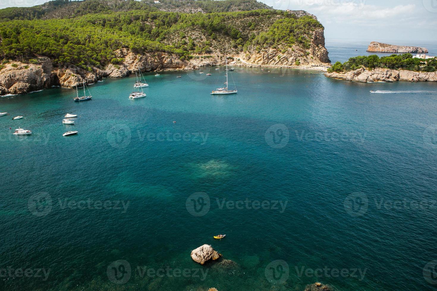 bellissima spiaggia con acqua molto pulita e azzurra sul mar mediterraneo nell'isola di ibiza, in spagna foto