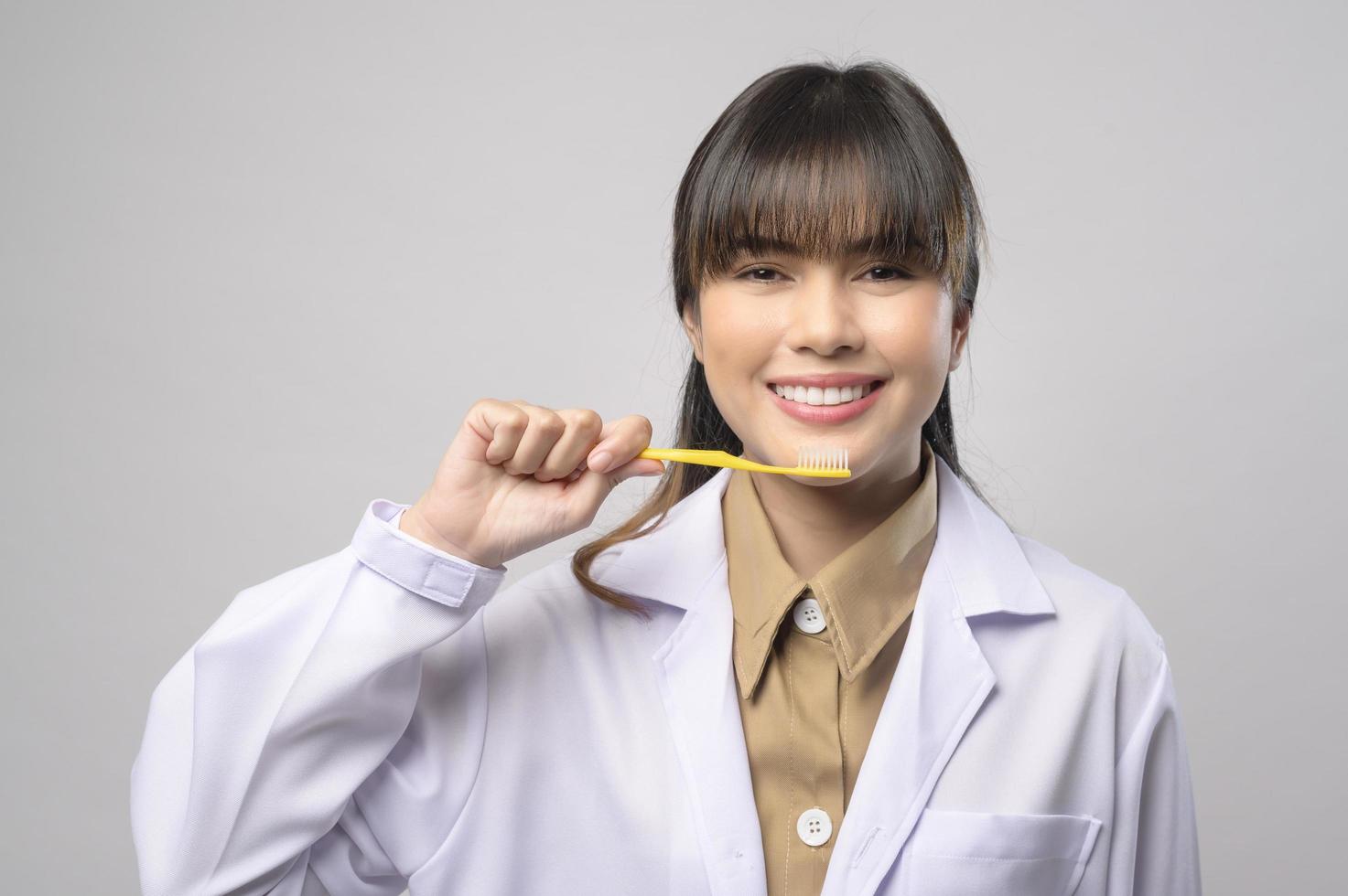 giovane dentista femminile sorridente su sfondo bianco studio foto