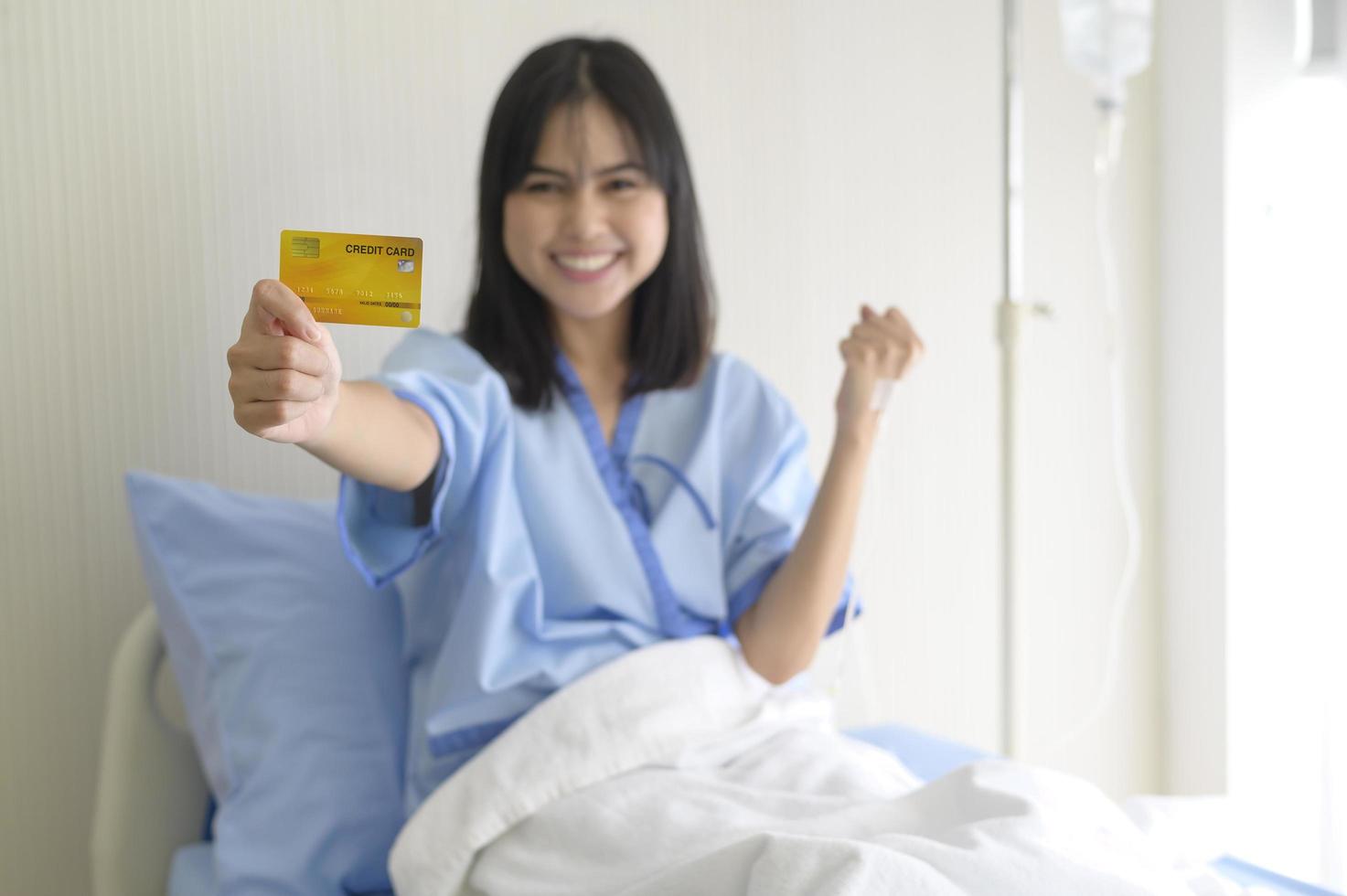 una giovane paziente è in possesso di carta di credito, ricoverato in ospedale, concetto di assistenza sanitaria foto