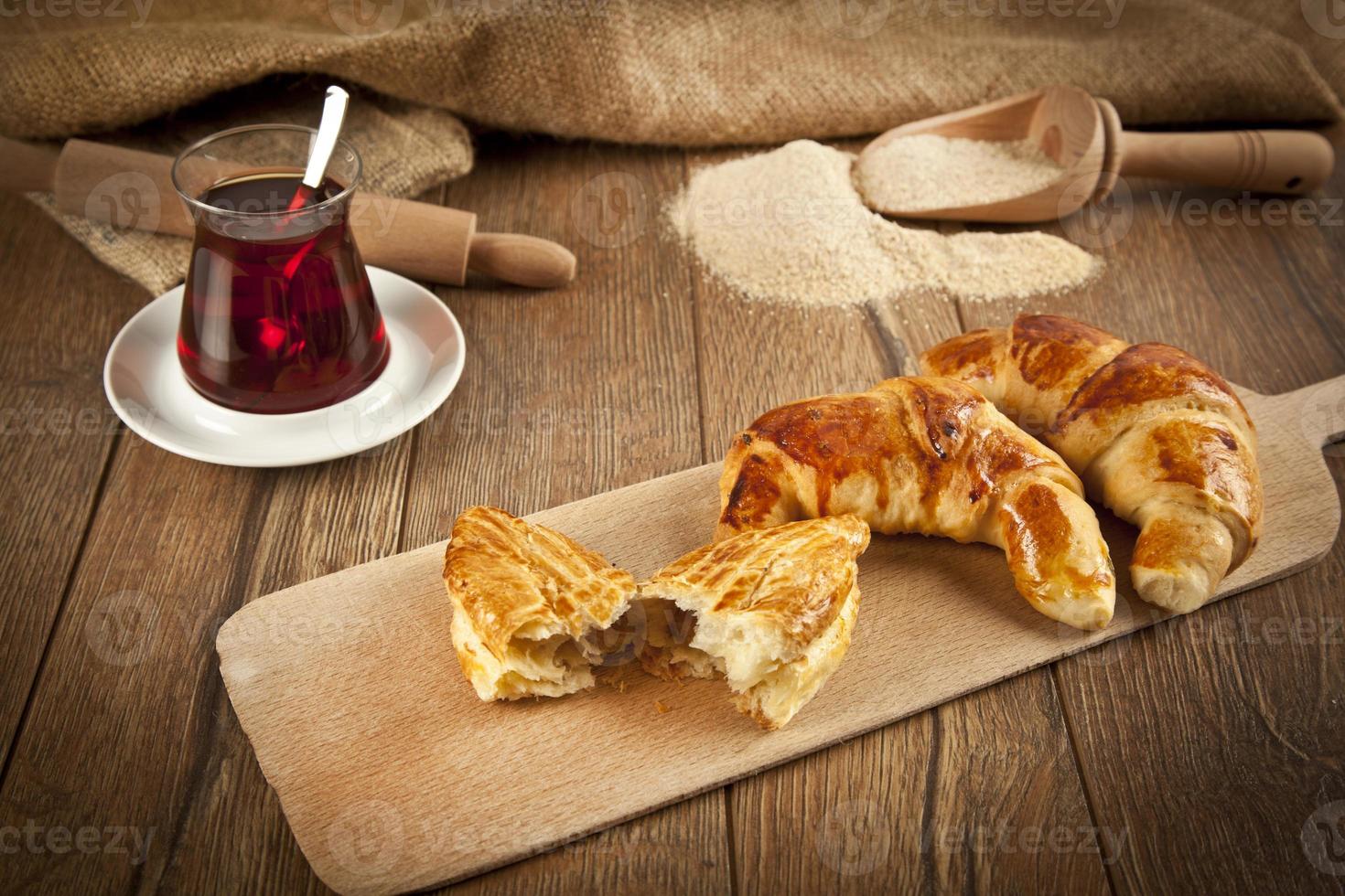 tipico pogaca di formaggio turco con piatto di legno e tè nero foto
