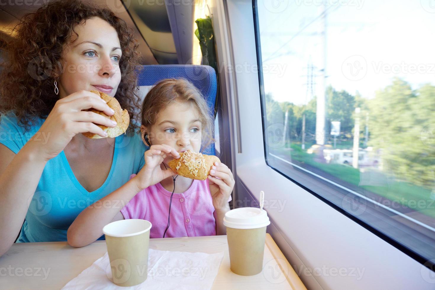 madre e figlia mangiano vicino alla finestra foto
