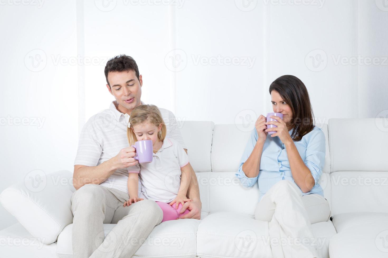 famiglia facendo colazione sul divano foto