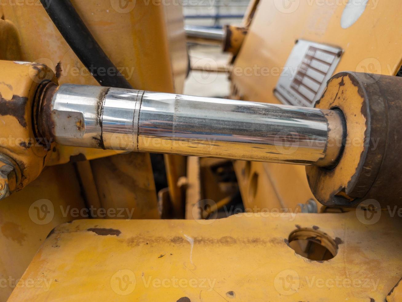 primo piano del cilindro idraulico con la macchia d'olio del piccolo bulldozer. foto