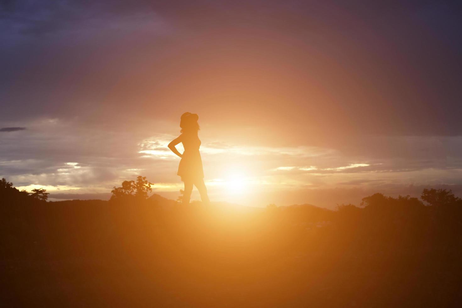 silhouette di donna che prega su sfondo bellissimo cielo foto