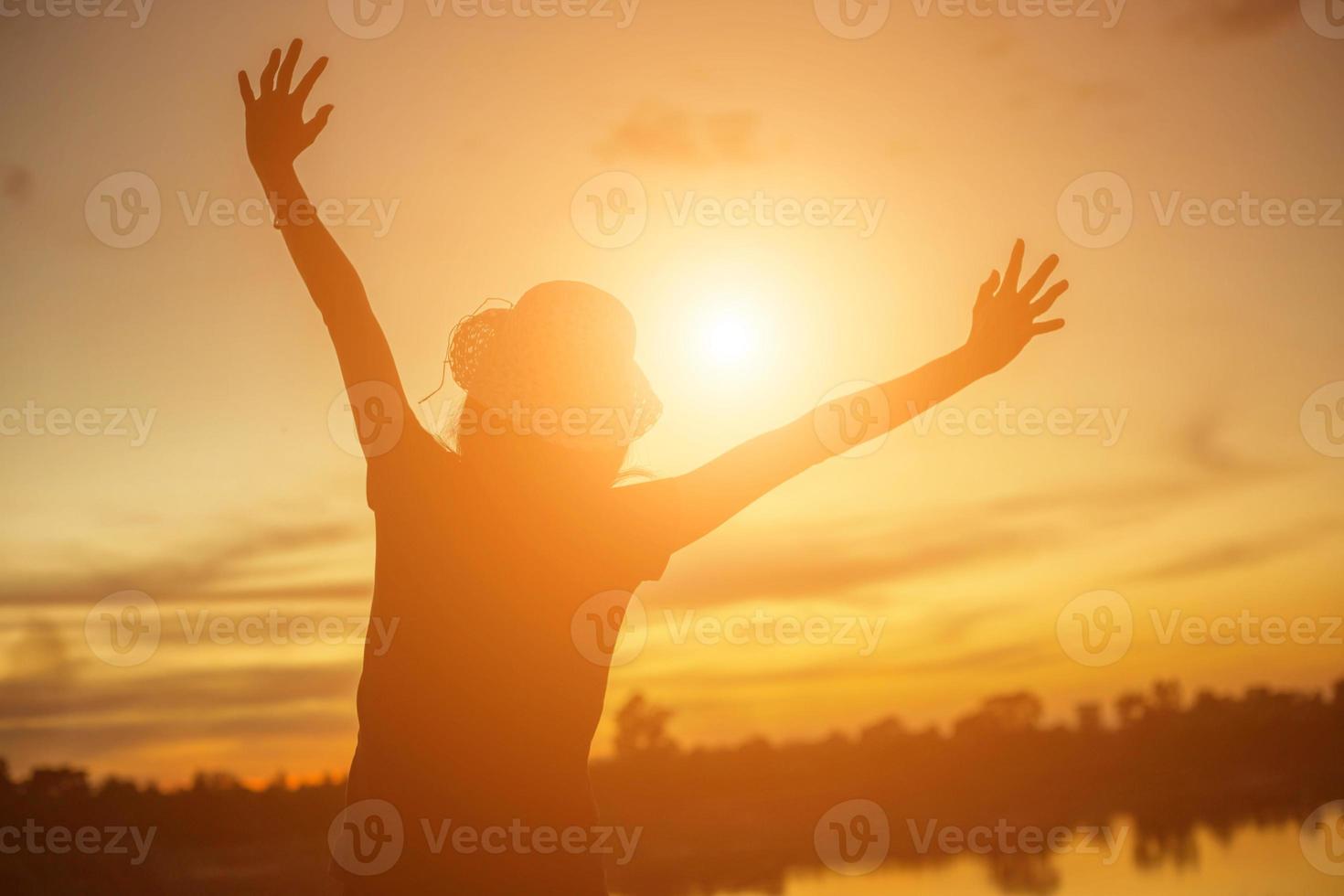 silhouette di donna che prega su sfondo bellissimo cielo foto