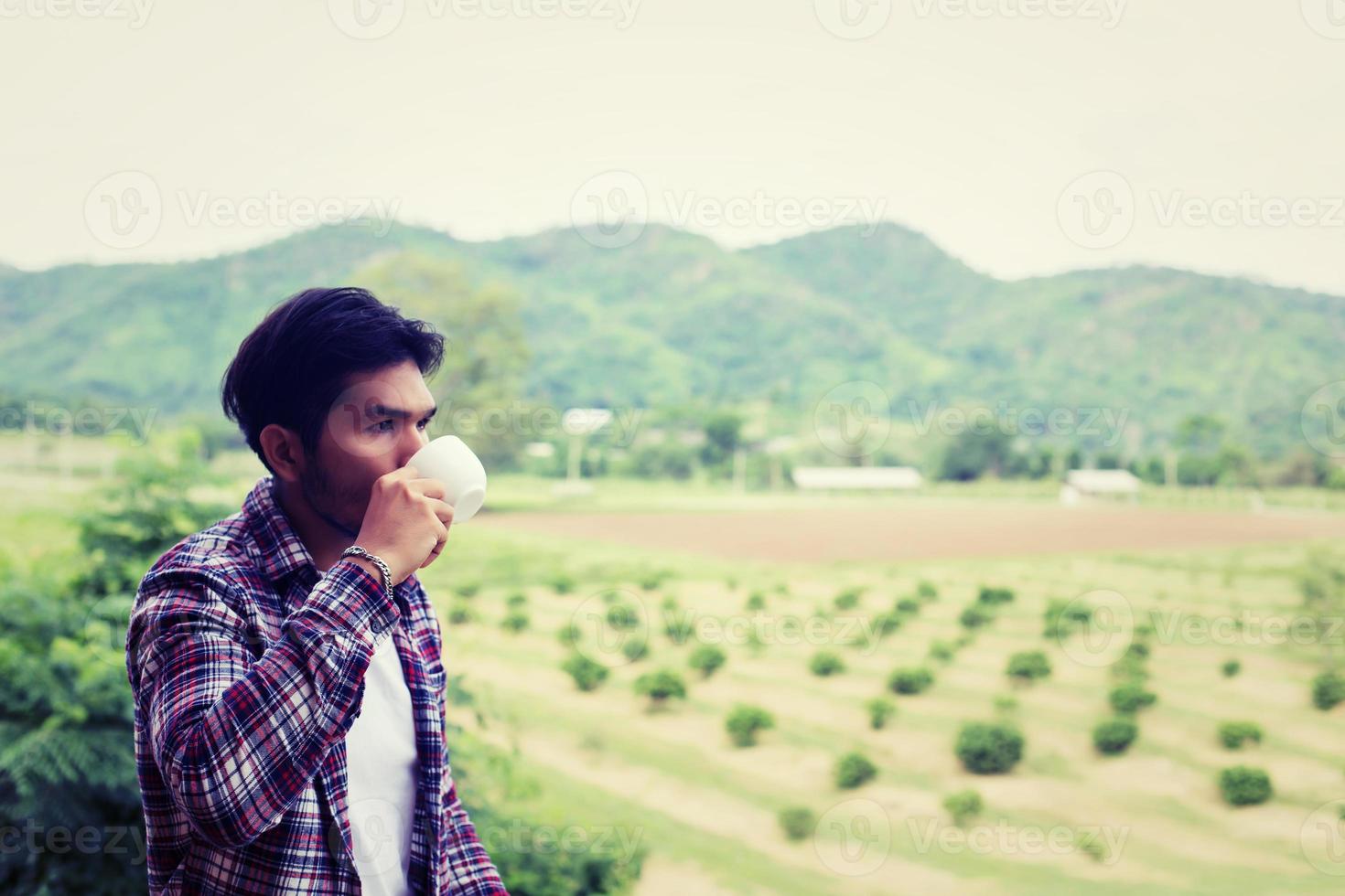 uomo barbuto bello hipster con una tazza di caffè mattutino che cammina nel parco. foto